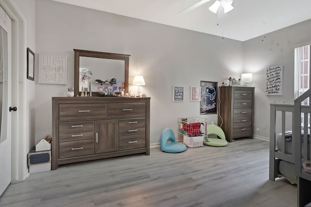 interior space featuring light wood-style floors, baseboards, and a ceiling fan