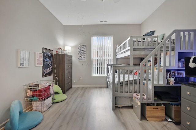 bedroom featuring wood finished floors, visible vents, and baseboards