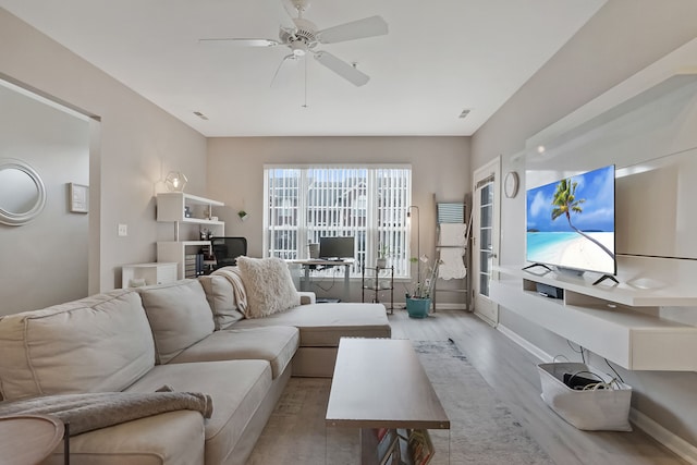 living room with visible vents, ceiling fan, baseboards, and wood finished floors