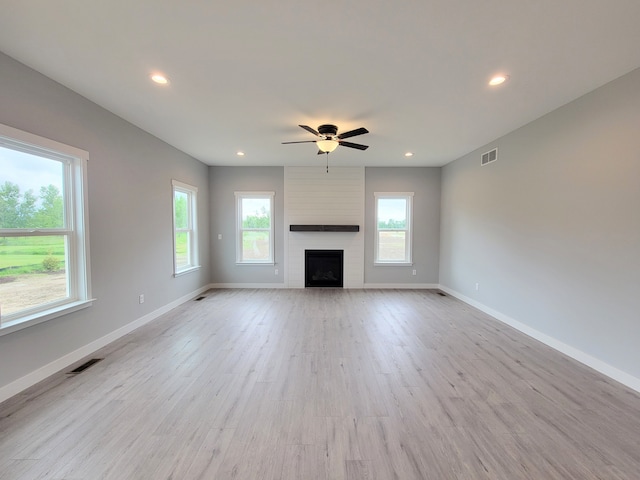 unfurnished living room with a wealth of natural light, light wood finished floors, baseboards, and recessed lighting