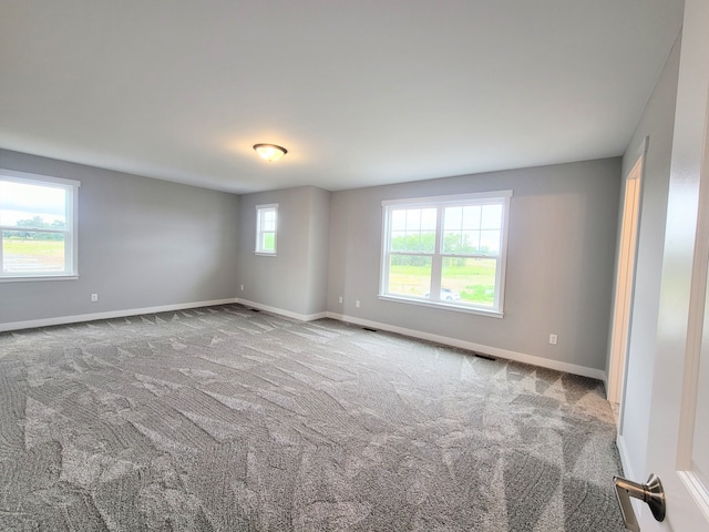 empty room with baseboards and light colored carpet