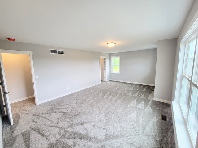 unfurnished room with light carpet, baseboards, and visible vents