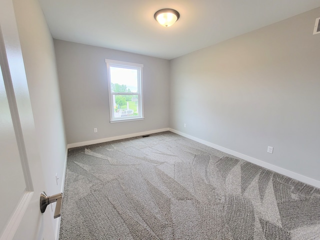 unfurnished room with light carpet, visible vents, and baseboards