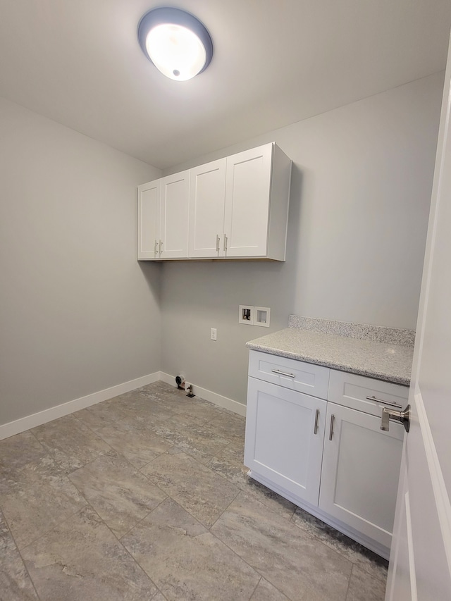 clothes washing area featuring hookup for a washing machine, cabinet space, and baseboards