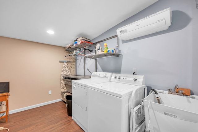 laundry room featuring washing machine and dryer, laundry area, wood finished floors, a sink, and baseboards