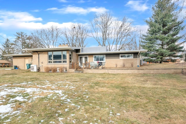 view of front of property featuring a front yard, brick siding, and a chimney