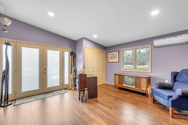 sitting room with recessed lighting, wood finished floors, vaulted ceiling, french doors, and a wall mounted air conditioner