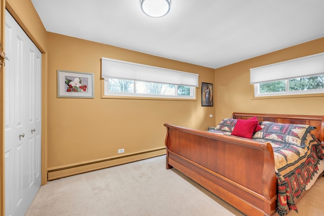 bedroom featuring a baseboard radiator, multiple windows, a closet, and light colored carpet