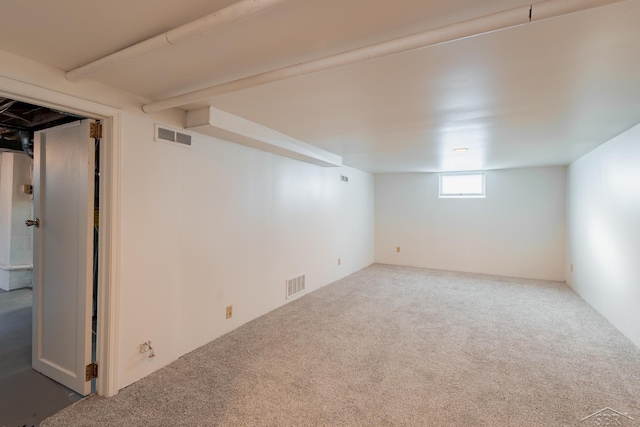 below grade area with carpet floors and visible vents