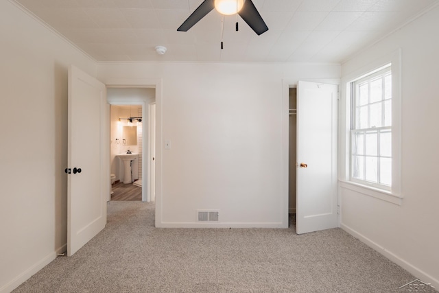 unfurnished bedroom with light carpet, ornamental molding, and baseboards