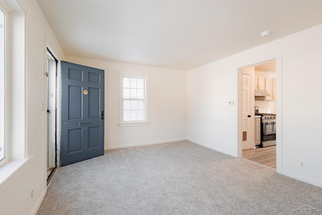 foyer entrance with light colored carpet and baseboards