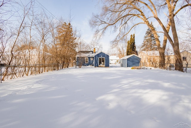 view of front of property featuring fence and an outdoor structure