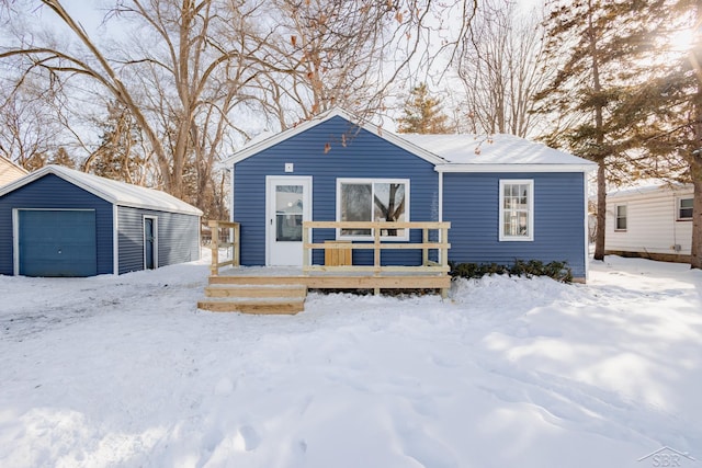 view of front of home with a garage, a deck, and an outdoor structure