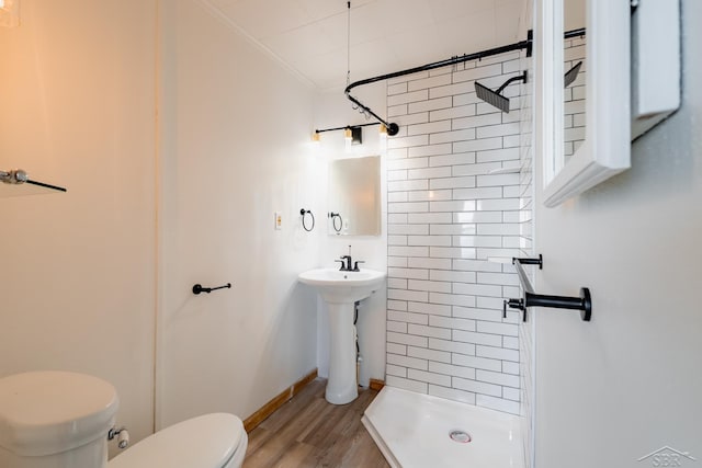 full bath featuring toilet, wood finished floors, baseboards, a stall shower, and crown molding