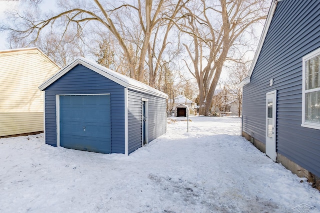 snow covered garage featuring a garage