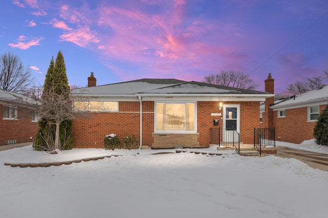 view of front of home with brick siding and a chimney