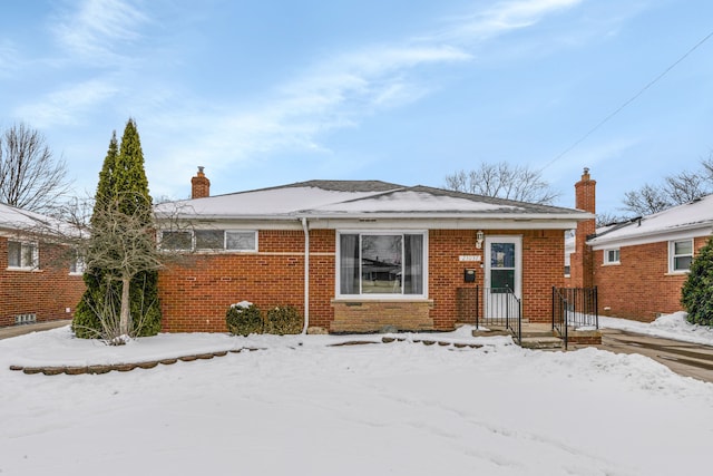 view of front of property with a chimney and brick siding