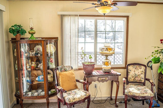 sitting room with ceiling fan and carpet