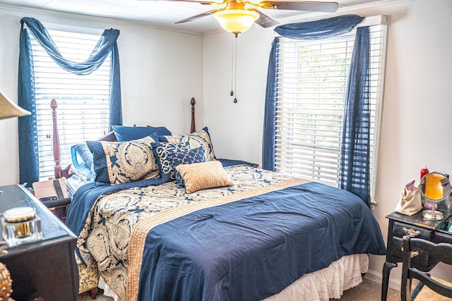 carpeted bedroom featuring ceiling fan and crown molding