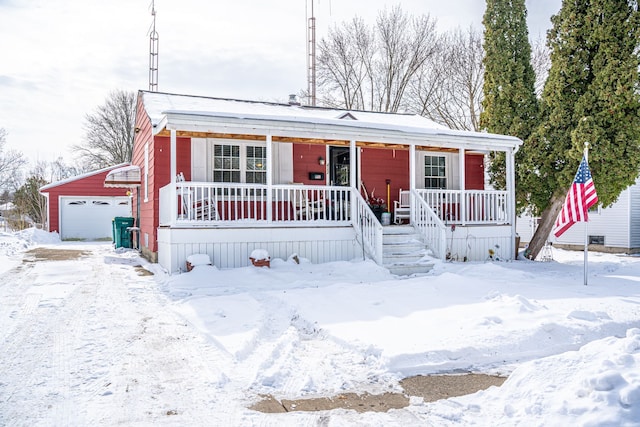 manufactured / mobile home featuring a detached garage, a porch, and an outdoor structure