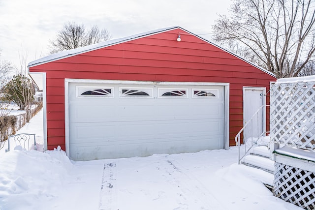 snow covered garage featuring a garage