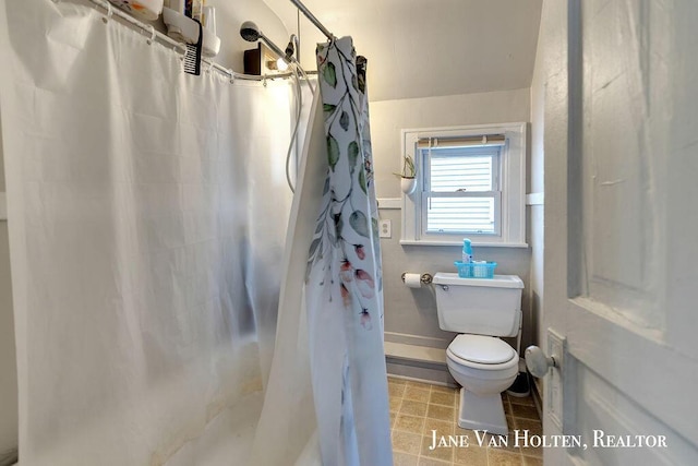 bathroom featuring curtained shower, tile patterned flooring, and toilet