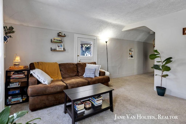 living room featuring lofted ceiling, baseboards, a textured ceiling, and light colored carpet