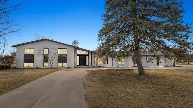 view of front of property featuring driveway, a front lawn, and brick siding