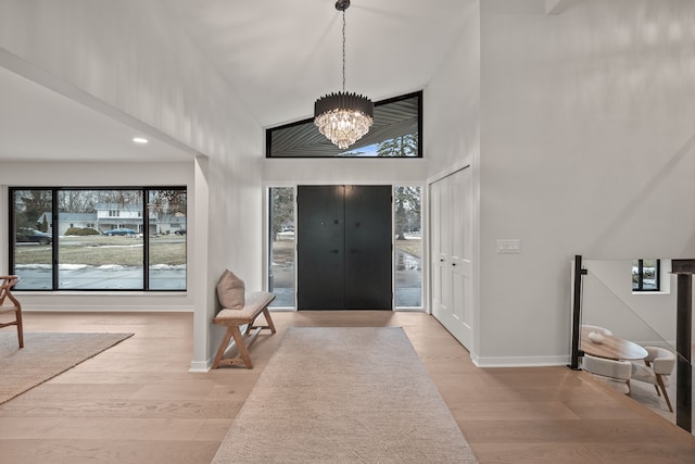 entryway with a chandelier, a high ceiling, wood finished floors, and baseboards