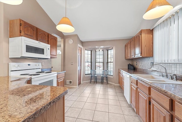 kitchen featuring brown cabinets, visible vents, hanging light fixtures, a sink, and white appliances