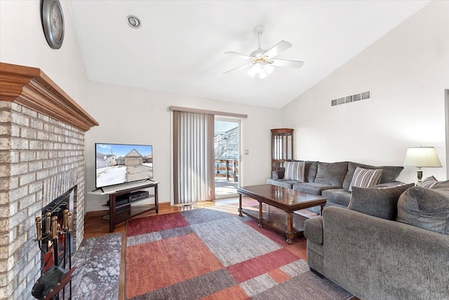 living area featuring visible vents, a ceiling fan, lofted ceiling, dark wood-type flooring, and a fireplace