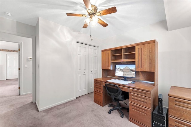 office space featuring baseboards, a ceiling fan, and light colored carpet