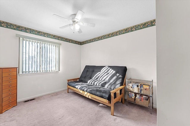 living area featuring baseboards, ceiling fan, visible vents, and carpet flooring