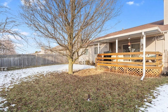 yard layered in snow with a deck and fence