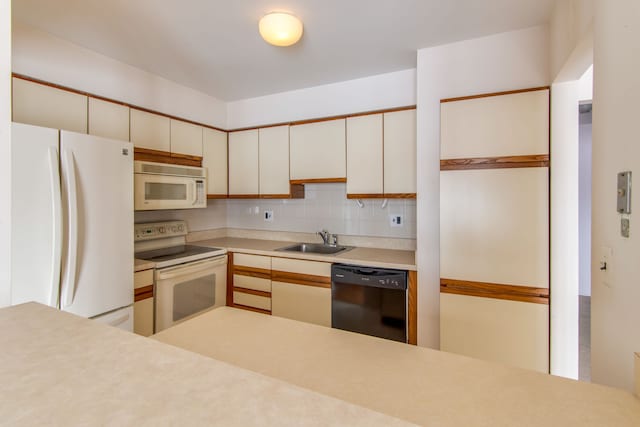 kitchen with white appliances, a sink, white cabinetry, light countertops, and tasteful backsplash