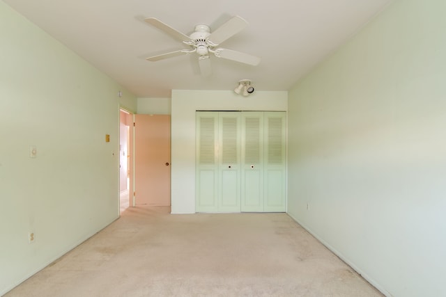 unfurnished bedroom featuring a closet, a ceiling fan, and light colored carpet