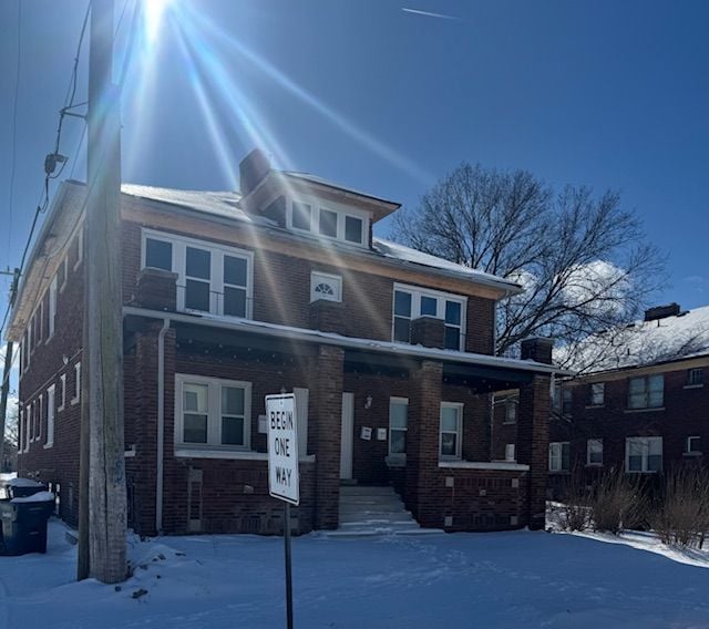 american foursquare style home featuring brick siding