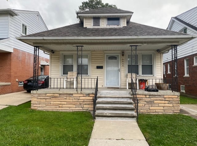 bungalow-style house with a porch and roof with shingles