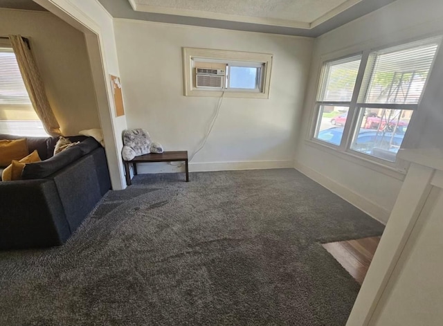 interior space with a raised ceiling, cooling unit, and baseboards