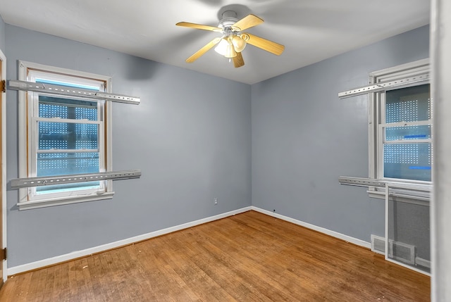 unfurnished room featuring visible vents, ceiling fan, baseboards, and wood finished floors