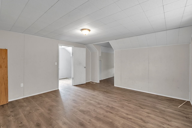 spare room featuring vaulted ceiling and wood finished floors