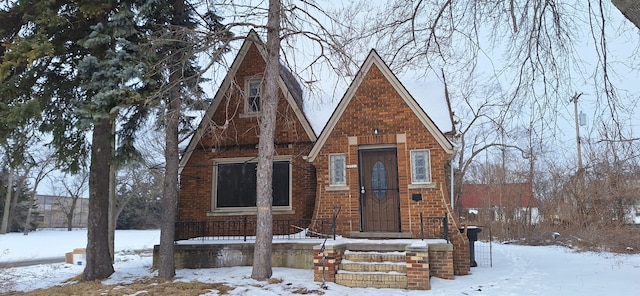 tudor home featuring brick siding