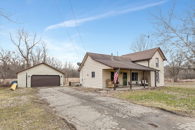 view of front of house featuring a porch, an outdoor structure, a detached garage, and a shingled roof