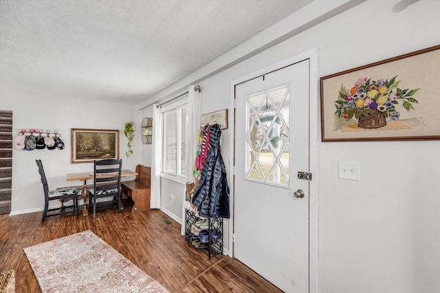 entrance foyer with baseboards, stairway, a textured ceiling, and wood finished floors