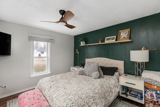 bedroom with a textured ceiling, wood finished floors, a ceiling fan, and baseboards