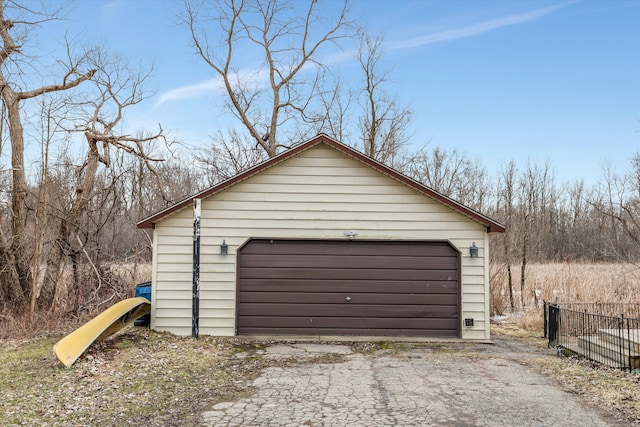 detached garage featuring fence