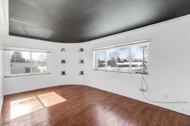 unfurnished room with a wealth of natural light and wood finished floors