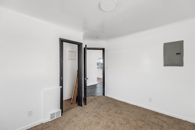 carpeted empty room featuring electric panel, visible vents, and baseboards