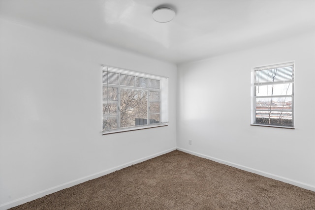 carpeted spare room featuring baseboards