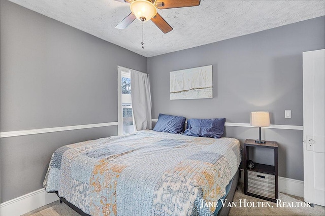 bedroom with carpet floors, a textured ceiling, baseboards, and a ceiling fan